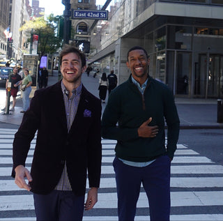 Two men crossing a street at an intersection in an urban setting.